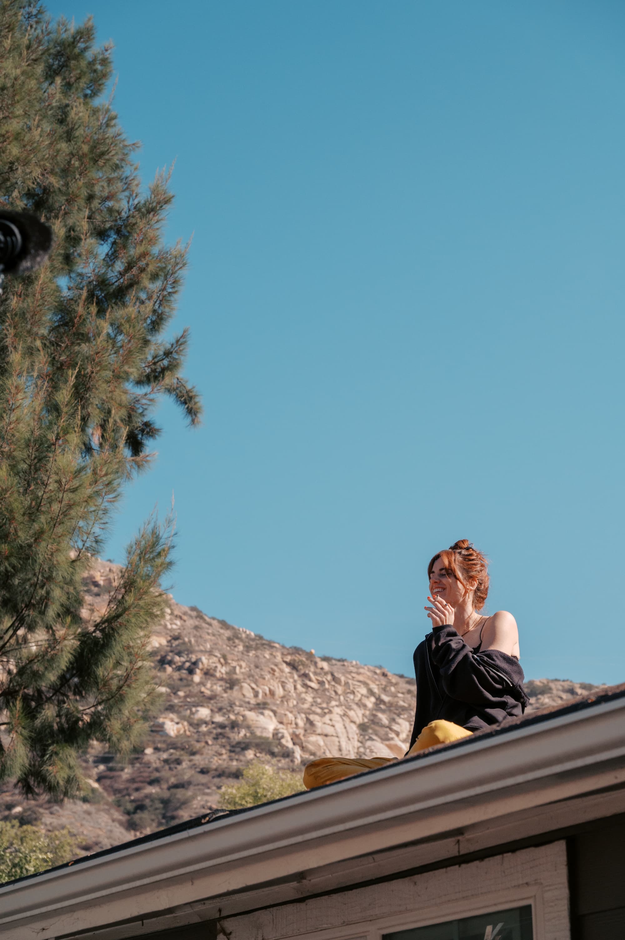 Actor on rooftop against blue sky